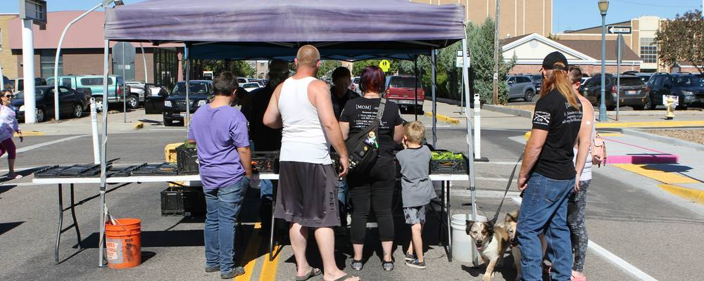 Utah residents receiving help at a food pantry and housing office, representing community resource access.